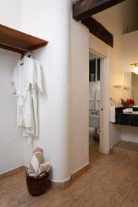 a bathroom with a white robe and shoes on a wall at Casa Bonita and villas in Isla Mujeres
