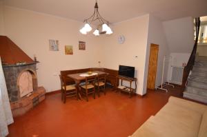 salon ze stołem i kominkiem w obiekcie Baldini Holiday House w mieście Montopoli in Val dʼArno