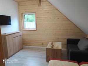 a living room with a couch and a window at Rodinný penzion U Hafana a U Hospůdky in Řeka