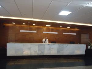 レシフェにあるGolden Beach Flat Recifeのロビーの窓口の後ろに立つ男 +45枚の写真