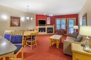 a living room with a dining table and a living room with red walls at Carriage Ridge Resort, an Ascend Collection Resort in Oro-Medonte