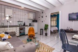 uma sala de estar com um sofá e uma cozinha em CityLife Apartments in Willemstad - groundfloor 2 bedroom apartment - B em Willemstad