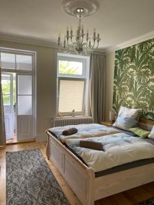 a bedroom with a large bed with a chandelier at Schöne Ferienwohnung in der City Königswohnung Jun in Kiel