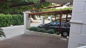 a car parked under a pergola next to a building at Apartments Jani in Hvar