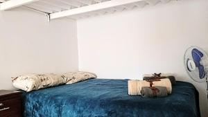 a bedroom with a bed with a blue blanket at Dulcinea Mini House in Salinas