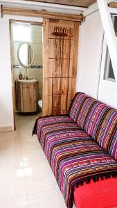 um sofá vermelho num quarto com um espelho em Dulcinea Mini House em Salinas