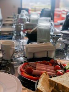 a table with hot dogs on a plate and sandwiches at Pensiunea Trecatoarea Lupilor in Burda