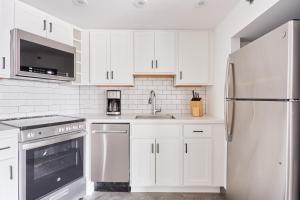 a kitchen with white cabinets and a stainless steel refrigerator at Sonder at The Terrace in Philadelphia