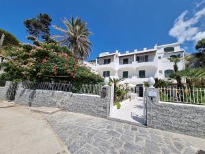 un bâtiment blanc avec une clôture et des arbres dans l'établissement Villa Bina Sea Hotel, à Ischia