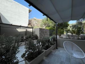 une terrasse avec des plantes, une chaise et un parasol dans l'établissement Opuntia rooms, à Milazzo
