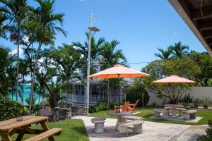 a patio with two picnic tables and two umbrellas at Orange Hill Beach Inn in Nassau