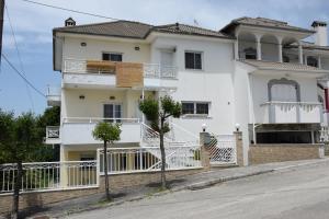 une maison blanche avec une clôture devant elle dans l'établissement Spacious Apartment at Ioannina, Anatoli, à Anatolí