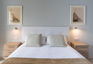 een slaapkamer met een wit bed en 2 spiegels bij Villas Maribel Pocillos in Puerto del Carmen