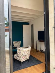 a living room with a chair and a television at Villa du bassin -un petit coin de paradis in Andernos-les-Bains