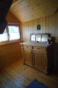 eine Küche in einer Holzhütte mit einem Fenster in der Unterkunft Knuschbrhaisle in Oberreute
