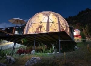 um edifício abobadado com uma cúpula de vidro à noite em Glamping La Villa em Guatavita