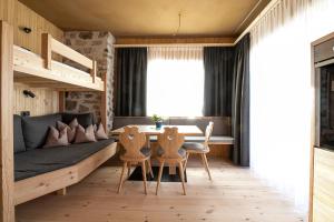 a room with a bed and a table and chairs at Ritschhof in Castelrotto