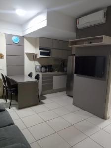 a kitchen with a table and a television in a room at Quartier das águas in Barra do Piraí