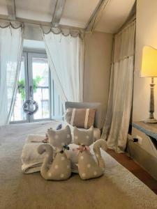 two stuffed animals sitting on a bed in a bedroom at Cortona Shabby Chic House in Cortona