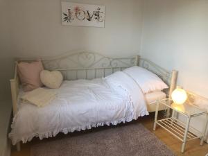 1 cama con sábanas blancas y almohadas en una habitación en von Fehrn, en Nortorf
