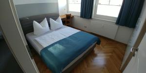 een slaapkamer met een bed met blauwe lakens en kussens bij attraktives 2-Zimmer-Apartment im Stadtzentrum in Rudolstadt