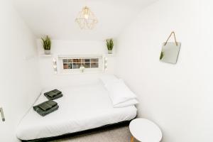 a white bedroom with a white bed and a window at New city house, great location - with parking in Norwich