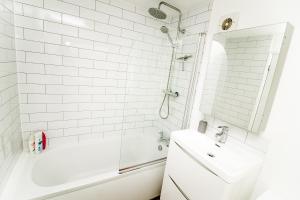 Un baño blanco con lavabo y ducha. en New city house, great location - with parking, en Norwich 11 fotos más