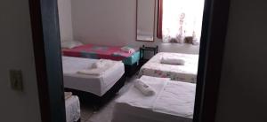 a room with three beds and a mirror at Casa da cachoeira na beira do Rio Sana in Sana