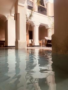 une piscine d'eau dans la cour d'un bâtiment dans l'établissement Riad Bamboo Suites & Spa, à Marrakech