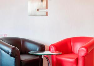 2 sillas de cuero y una mesa en una habitación en Hotel Puente Grande en Las Ánimas