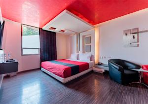 Habitación de hotel con cama y techo rojo en Hotel Puente Grande, en Las Ánimas