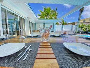 una mesa de comedor con platos blancos y cubiertos en Villa Zandoli, walkable Orient Bay beach, private pool en Orient Bay
