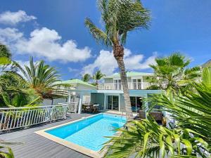 ein Haus mit einem Pool und Palmen in der Unterkunft Villa Zandoli, walkable Orient Bay beach, private pool in Orient Bay