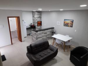 Residencial Quinta dos Açores في غاروبابا: غرفة معيشة مع كرسي جلدي أسود وطاولة