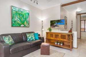 ein Wohnzimmer mit einem Sofa und einem Flachbild-TV in der Unterkunft Hibiscus Resort 10 ~ Fabulous location in Port Douglas