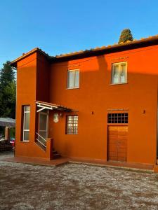 uma casa laranja com duas portas e uma garagem em Dimora Toscana em Treggiaia