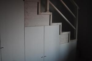 um armário branco num quarto com uma escada em Dimora Toscana em Treggiaia