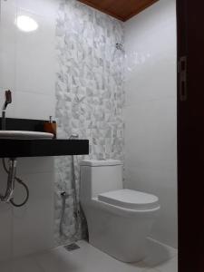 uma casa de banho com um WC branco e um lavatório. em Loft Colibri Mucugê em Mucugê