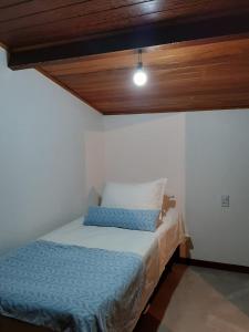 um pequeno quarto com uma cama e um tecto em Loft Colibri Mucugê em Mucugê