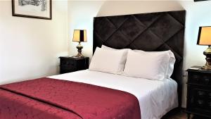 a bedroom with a large bed with a red blanket at Casa Dos Gomes in Viseu