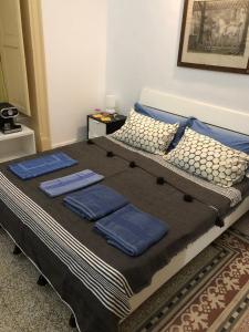 a bed with three blue pillows on top of it at B&B Giulio Cesare 24 in Palermo