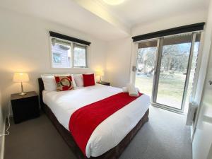a bedroom with a large bed with a red blanket at Humffray 3 in Dinner Plain