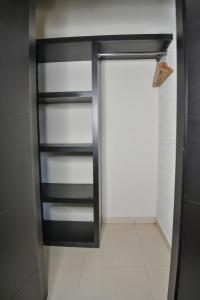 a closet with black rails and a white tile floor at Hotel Portonovo Plaza Guadalajara in Guadalajara +18 photos