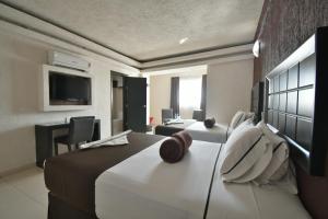 een hotelkamer met een groot bed en een televisie bij Hotel Portonovo Plaza Centro in Guadalajara