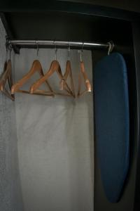 a rack with hangers and a surfboard in a room at Hotel Portonovo Plaza Centro in Guadalajara