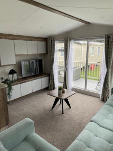 a living room with a couch and a table at Lazy Bear Lodge Northumberland in Swarland