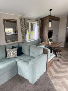 a living room with a couch and a table at Lazy Bear Lodge Northumberland in Swarland