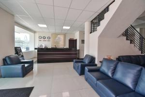 a waiting room with blue leather chairs and stairs at Hotel Portonovo Plaza Centro in Guadalajara