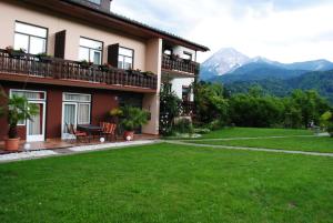 una casa con un giardino verde con montagne sullo sfondo di Ferienhaus Michor a Latschach ober dem Faakersee