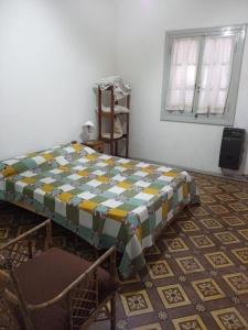 a bed in a room with a table and chairs at Family Place II in Luján